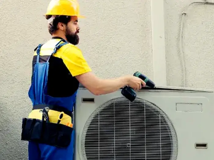 Vayu AC Service technician servicing an outdoor AC unit at a home in Greater Noida